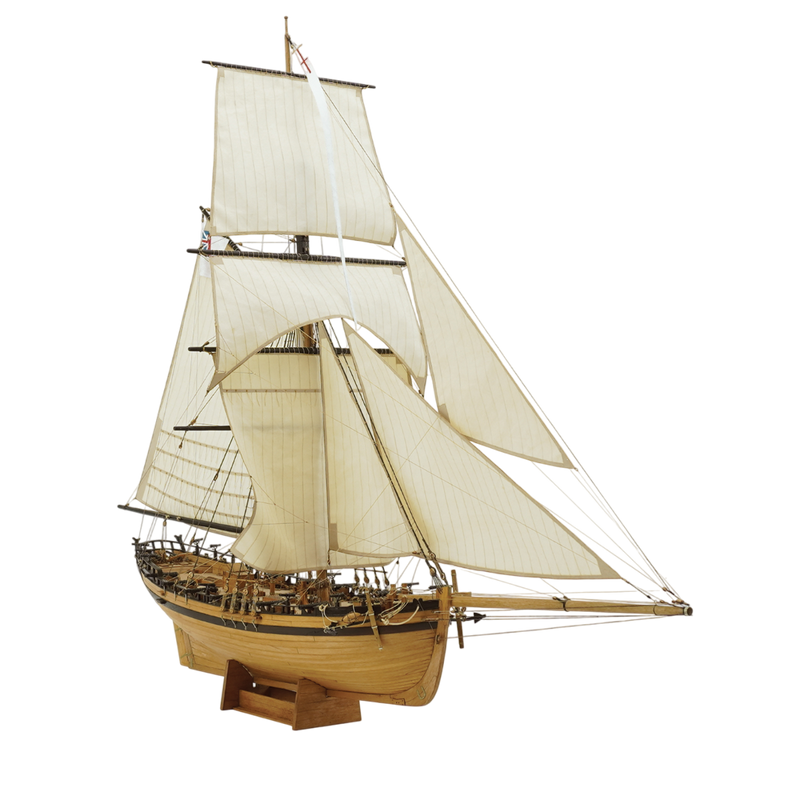 Photo of the HMS Rattlesnake 1776 wooden model kit by Shipyard in 1:72 scale, showing laser-cut parts, brass details, rigging accessories, and sails.