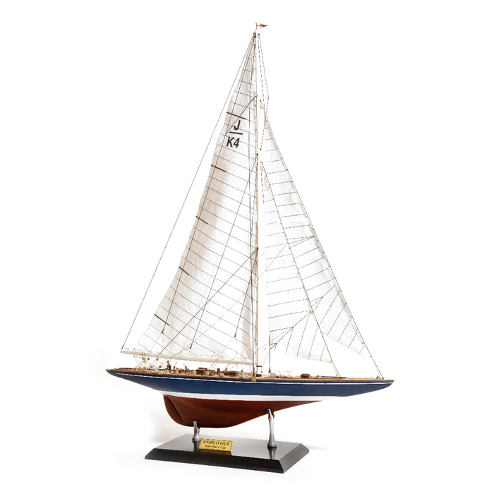Photo of the OcCre Endeavour America's Cup yacht model kit in 1:75 scale, showing detailed wooden hull, rigging, and classic sail design.