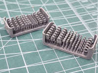 Two trays of small figurines on a grid surface
