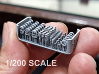 Close-up of a miniature model held between fingers with '1/200 SCALE' text.