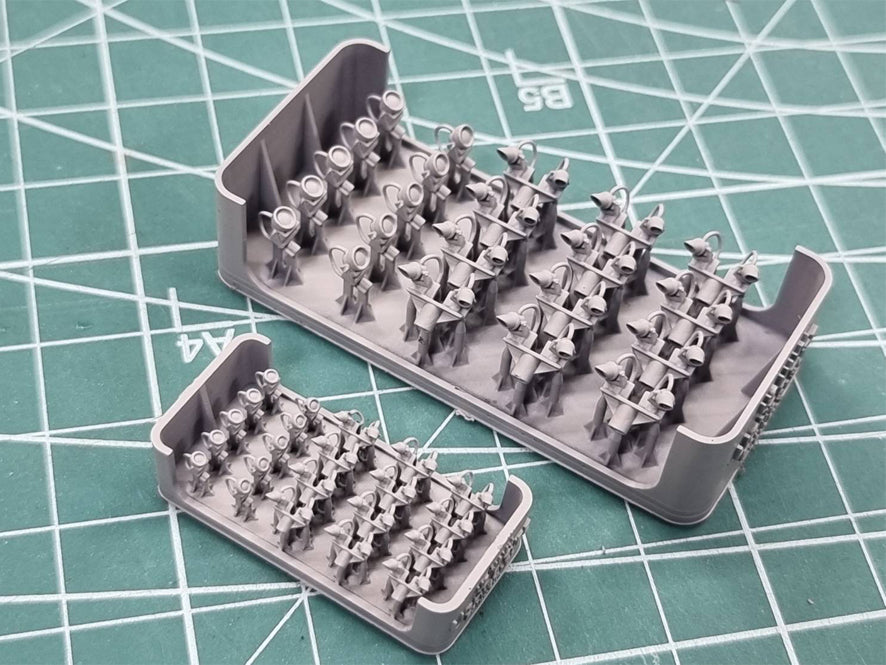 Set of miniature figures on a green cutting mat with grid lines