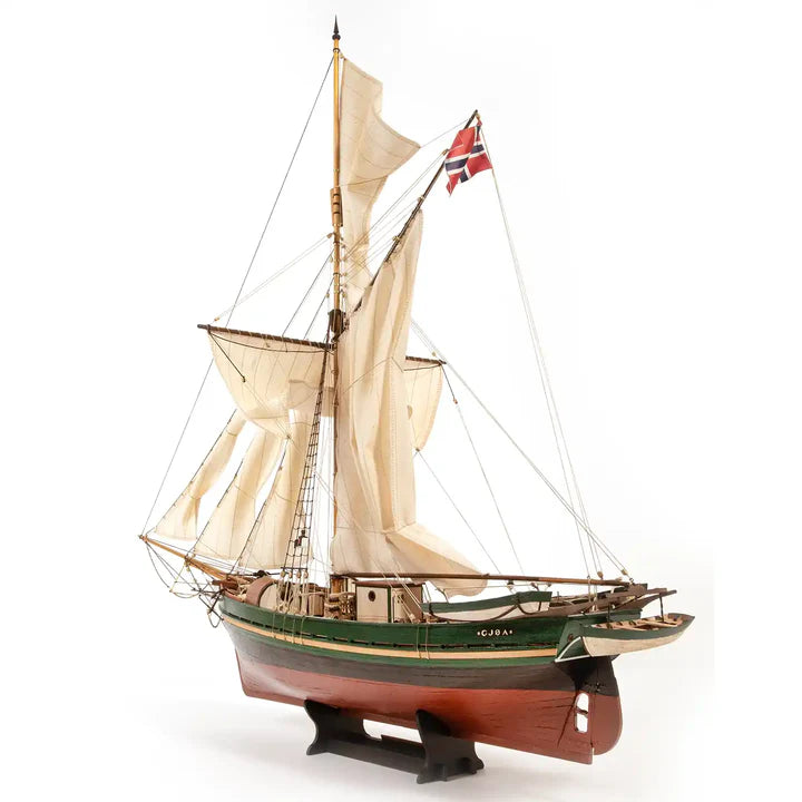 Model sailboat with white sails and a flag on a white background