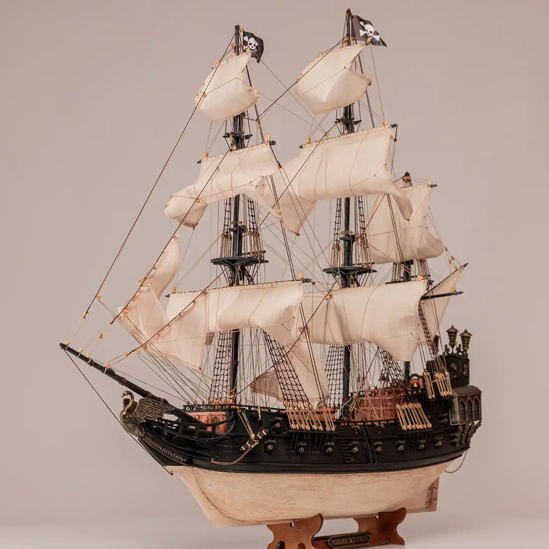 Photo of OcCre Black Swan wooden model ship kit 1:75 scale, detailed pirate vessel with sails and nameplate