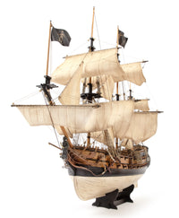 Model of a three-masted sailing ship with white sails on a white background