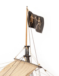 Pirate ship model with a black flag featuring skeletons on a white background