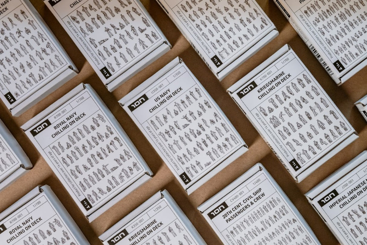 Photo of box with scale 3D printed resin crew figures on battleship deck