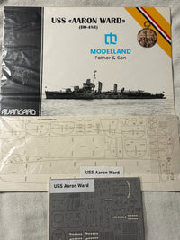 Model kit packaging and components for the USS 'Aaron Ward' (DD-483) by Modelland, including the front cover, a sheet of decals, and a sheet of model parts on a light fabric background.