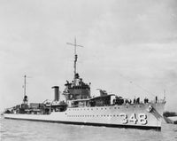 Black and white photograph of a military ship at sea, showing the hull number 348 on the side, with crew visible on deck and a cloudy sky in the background.