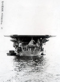 Black and white historical photograph of a large military aircraft carrier at sea, with Chinese characters printed along the left margin.