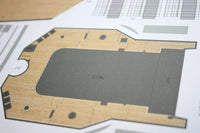 A close-up of a printed architectural floor plan or layout sheet, showing a large gray rectangular area with measurements and black line details on a white page.
