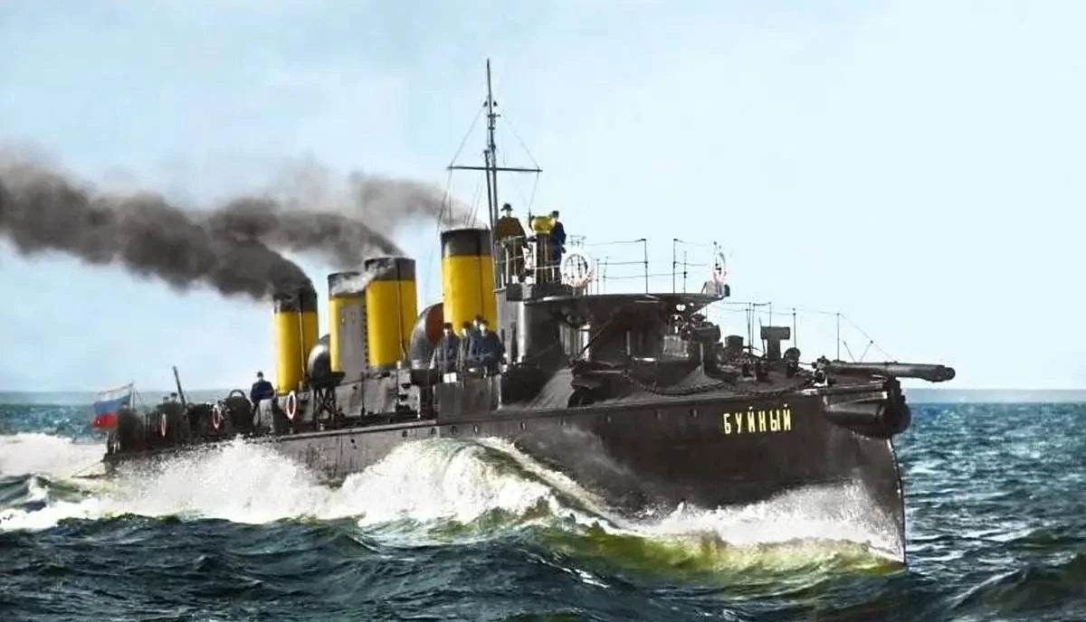 A black naval warship with yellow funnels and the name 'СУХУН' in yellow letters on the side, sailing through choppy blue-gray ocean water with dark smoke billowing from its engines.