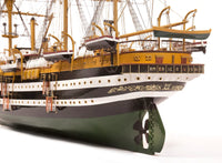 Photo of OcCre Amerigo Vespucci 1:100 wooden model ship kit without sails, showing detailed hull and brass photo-etch parts.