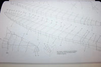 A close-up of a printed technical diagram or instruction sheet showing a long boat or hull outline with labeled parts and small text, photographed on a white background.