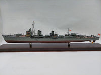 A detailed model of a Japanese military ship displayed on a dark wooden base against a plain light gray background.