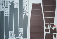 A flat lay of two printed sheet components, likely model kit parts or craft templates. The left sheet features gray striping and decals on a white background, while the right sheet features brown fabric or paper panels arranged in geometric shapes.