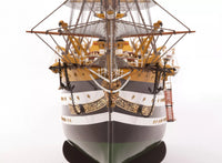 Photo of OcCre Amerigo Vespucci 1:100 wooden model ship kit without sails, showing detailed hull and brass photo-etch parts.