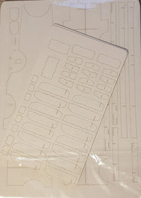 A laser-cut foam panel or craft sheet with multiple pre-cut slots and compartments, shown partially covered by a clear plastic protective sleeve.