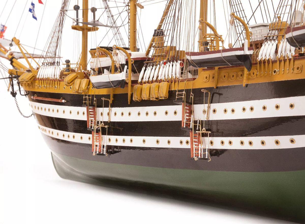 Photo of OcCre Amerigo Vespucci 1:100 wooden model ship kit without sails, showing detailed hull and brass photo-etch parts.