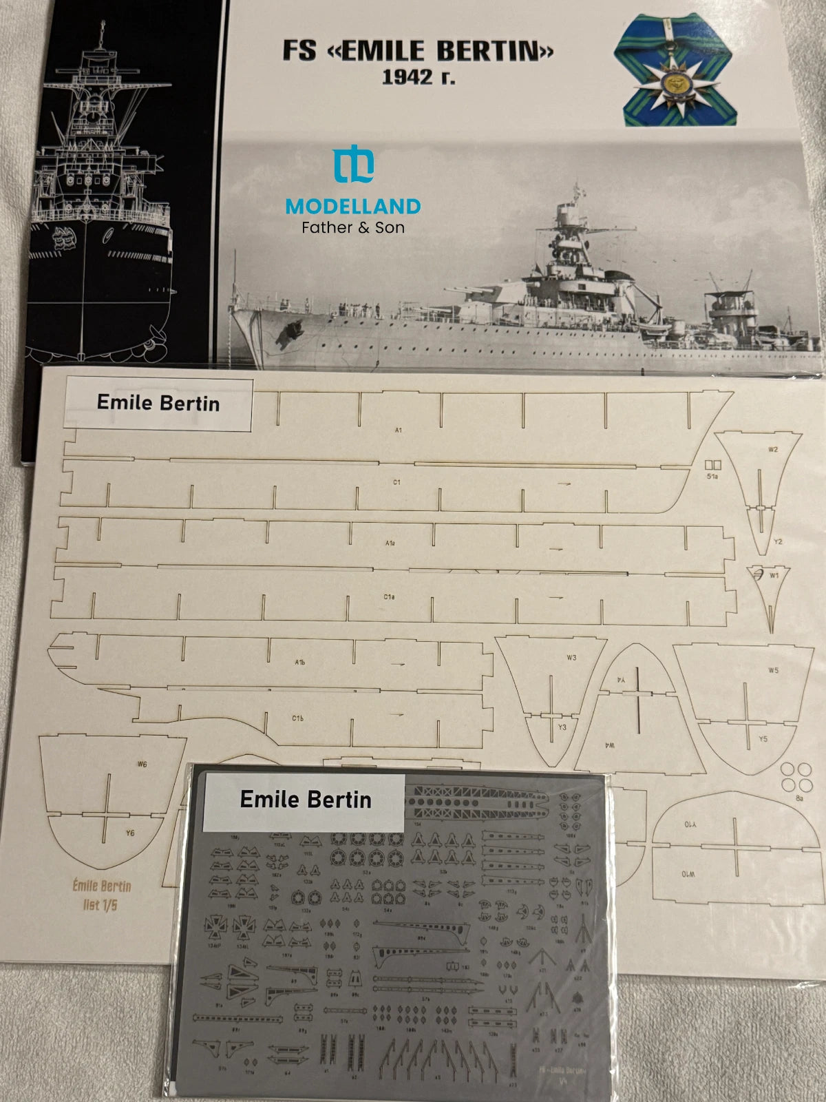 Model kit parts and decals for a FS Émile Bertin 1842 r. battleship, shown with the printed instruction sheet, a smaller sheet of decals, and the Modelledland Father & Son branded box cover.
