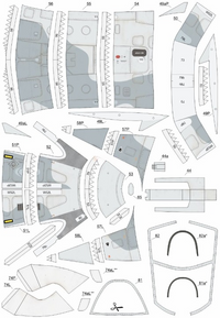A flat lay of multiple labeled paper template or panel pieces arranged on a white background, likely a model-making or craft kit sheet. The pieces are mostly white with light gray shaded areas, black outlines, and small printed labels or markings.